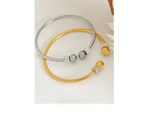 Close-up of gold and silver snake bone texture bracelets with crystal encrusted beads