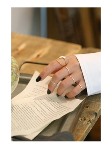 Close-up of irregular hammered silver rings and gold pearl ring set on vintage pages
