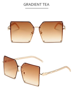 Detail of square oversized sunglasses with gold chain temples and gradient tea lenses