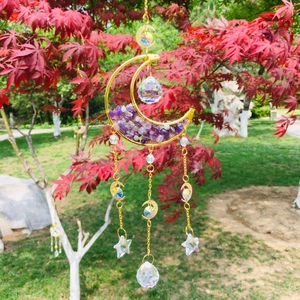 Detail of amethyst moon suncatcher with crystal prisms hanging on a red maple tree branch