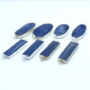 Macro view of natural blue kyanite connectors with gold and silver plated metal edging