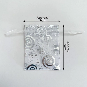 Detail view of a 7x9cm white organza drawstring bag with silver star print patterns