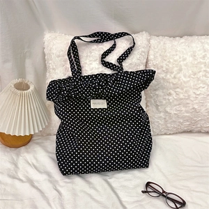 Polka dot canvas tote bag shown in a cozy home setting on white bedding and pillows