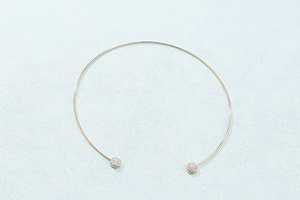 Detailed view of a gold minimalist open choker necklace with circular rhinestone ends