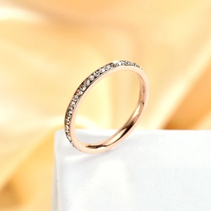 Detailed macro view of rose gold ring featuring a full circle of inlaid white zircon stones