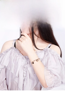 Detail showing a rose gold heart bracelet on a model's wrist with an adjustable chain