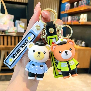 Detail of blue and green cartoon police bear keychains with silicone COOL BEAR straps