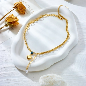 Double-layered gold necklace with blue teardrop stone, heart pendant and white pearl