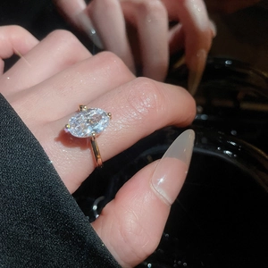 Macro shot of oval cut zircon ring with minimalist gold band and sparkling fire effect