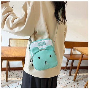 Detail of mint green cartoon bear crossbody bag worn diagonally on model back