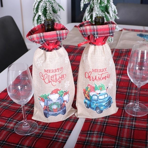 Housses de bouteilles de vin de Noël avec Père Noël et camion sur nappe à carreaux