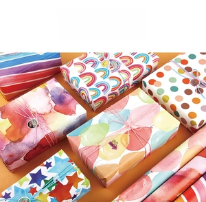 Detail von regenbogen gemusterten Geschenkpapierrollen und dekorierten Boxen