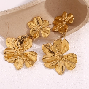 Detail of 18K gold-plated double flower earrings on a dewy background with ceramic props