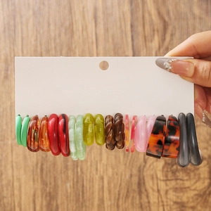 Détail de 8 paires de créoles colorées en résine acrylique sur carte de présentation