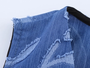 Detail of blue denim fabric with textured floral jacquard and black edge piping