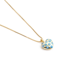 Close-up of golden heart pendant with blue and white evil eye patterns on link chain