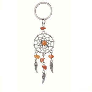 Detail of dream catcher keychain with natural orange crystal stones and silver metal feathers