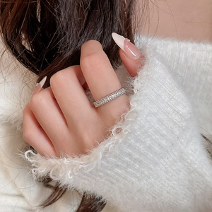 Close-up of elegant double-row zircon ring on model hand with warm knit background