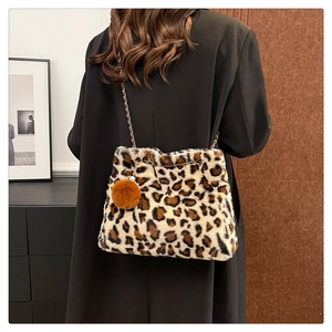Detail of leopard print plush bag with gold chain strap and brown faux fur pom pom