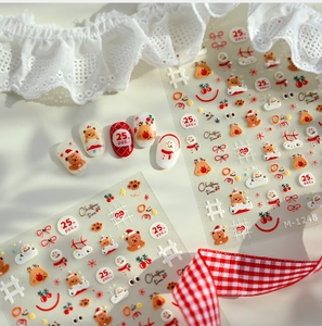 Close-up of Christmas nail stickers with bears, elk, and snowman patterns on white lace