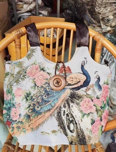 Detail der Ethno-Canvas-Tasche mit Pfauenstickerei und großem Holzknopfverschluss am Griff