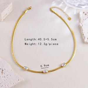 Detail view of gold snake chain necklace with three iridescent square gemstones and specs