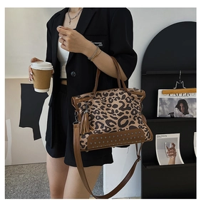 Brown leopard print tote bag with rivet details and tassels shown in a lifestyle setting