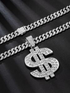 Macro detail of silver Cuban chain and dollar sign pendant with sparkling rhinestones