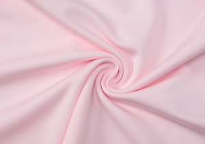 Close-up of pink knit fabric with soft texture and elegant spiral drapery detail