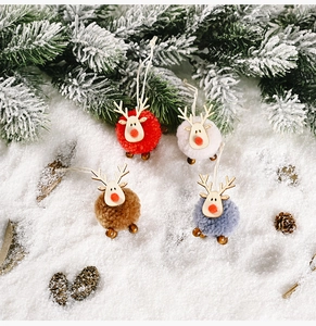 Detail of colorful felt reindeer ornaments with wooden heads on a snowy background