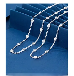 Macro view of 925 sterling silver chain with textured beads on a blue background