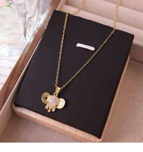 Close-up of a gold elephant pendant with inset crystals on a fine titanium chain necklace