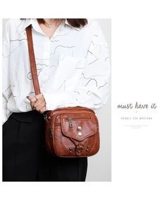 Détail du sac bandoulière vintage en cuir souple marron avec zips et rivets métalliques