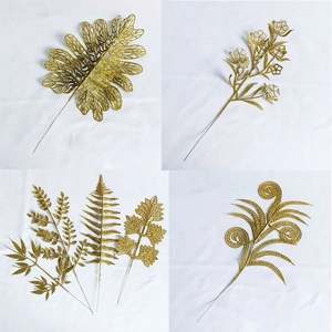 Detailed macro view of artificial gold glitter leaves in four unique shapes for holiday decor