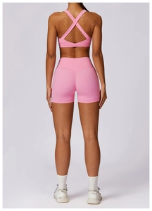 Rear view of pink cross-back sports bra and high-waist compression shorts set