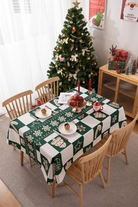 Close-up of green plaid Christmas tablecloth with festive snowflake and gift patterns