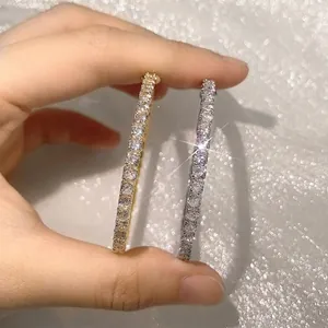 Classic gold and silver zircon pavé eternity hoop earrings for women shown on hand