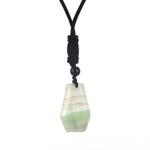 Detail shot of a natural green and white fluorite trapezoid pendant with black cord