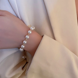 Minimalist pearl geometric bracelet with adjustable gold chain on female model wrist