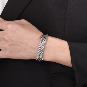 Close-up of men's woven black leather and silver titanium steel bracelet with magnetic clasp