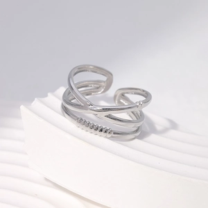 Detailed view of layered silver stainless steel open ring on a white marble tray