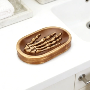 Skull hand resin soap dish holder in bronze brown on a minimalist bathroom sink