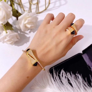 Detail view of gold jewelry set with pavé crystals and black geometric accents on model