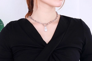 Detail of silver letter B necklace with irregular pearl pendant on a chunky chain