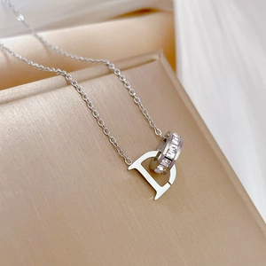 Detailed macro view of a silver titanium steel D-letter pendant with sparkling rhinestones