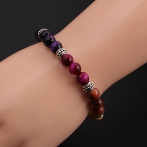 Detail of colorful 8mm tiger eye beaded bracelet with silver spacers on a model arm