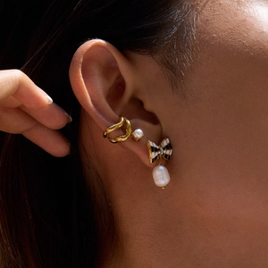 Elegant gold ear cuff and black white bow earring with drop pearl on model