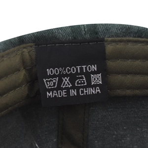 Detail of 100% cotton washing label and internal stitching on washed hummingbird cap