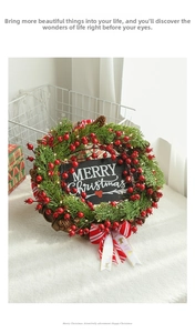 Detail of Christmas wreath with pine needles, red berries, cones, and Merry Christmas sign