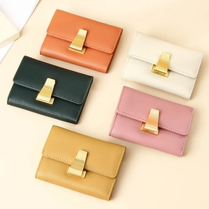 Flat lay of colorful pebble leather wallets with gold trapezoidal metal clasp details